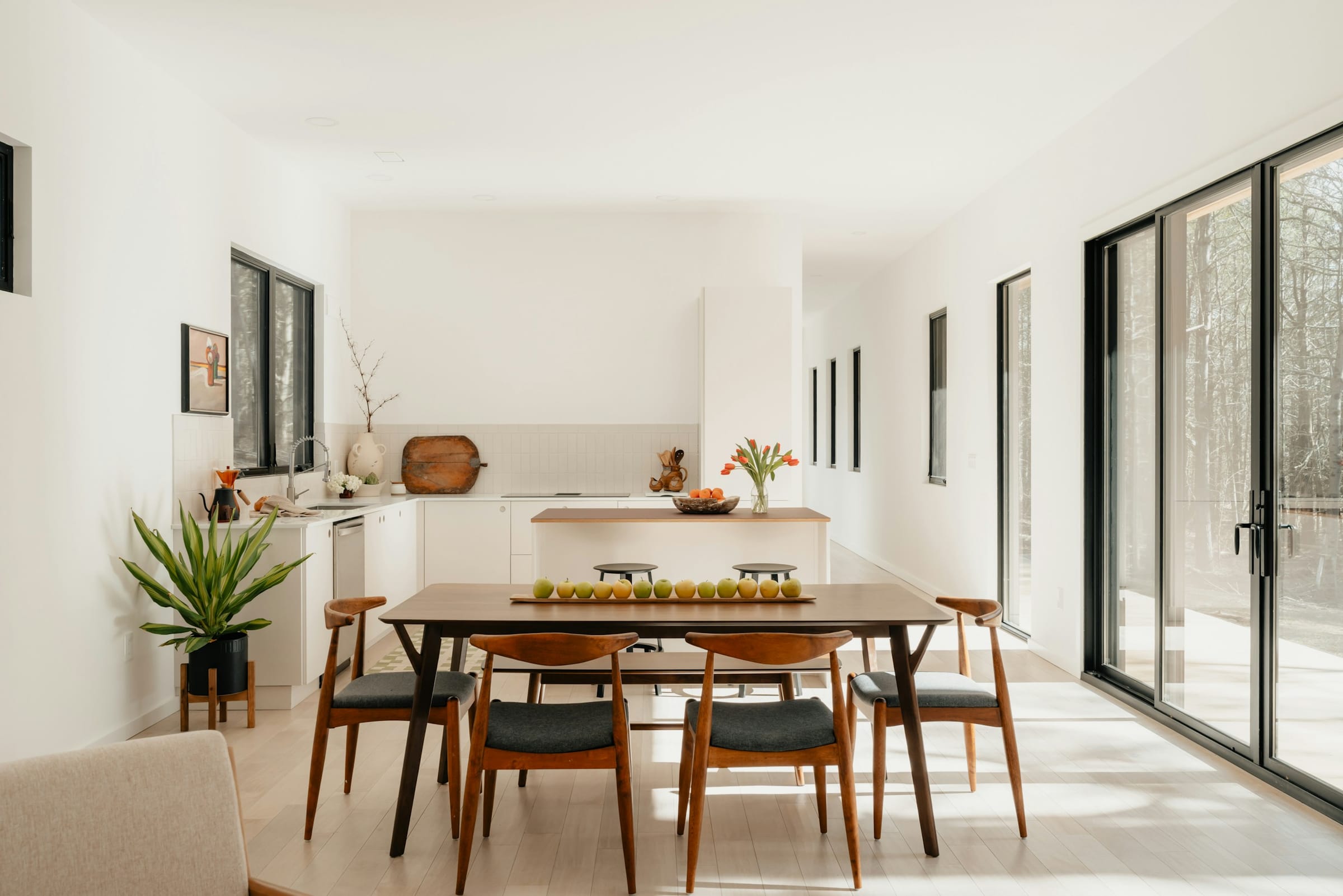 A bright open-plan dining and kitchen space with clean white walls.